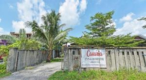 a sign on a fence in front of a house at OYO HOME 90646 Casaria Paka Homestay in Kampong Baru