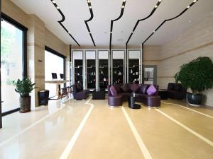 Cette grande chambre comprend des canapés, des tables et des fenêtres. dans l'établissement Shenzhen Lavande Hotel Airport Terminal Branch, à Baoan