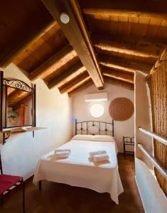 une chambre avec un lit blanc avec deux serviettes dessus dans l'établissement Casa Rural Privada Arenosos, à Pruna