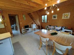 un soggiorno con un tavolo di legno e un divano di Gîte Chalet Morvan Bourgogne a Corancy