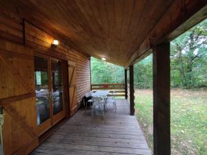 un portico di una cabina con tavolo e sedie di Gîte Chalet Morvan Bourgogne a Corancy