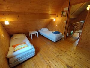 Camera mansardata con 2 letti e un tavolo. di Gîte Chalet Morvan Bourgogne a Corancy