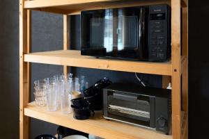 a microwave oven sitting on a shelf with glasses at HETA Niseko in Niseko