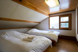 two beds in a small room with a window at HETA Niseko in Niseko
