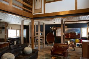 a living room with a leather couch and chairs at HETA Niseko in Niseko