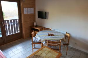 a dining room with a table and a balcony at Studio au pied des pistes - Vue montagne in Saint-Jean-d'Aulps