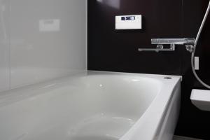 a white bathroom with a tub and a sink at HETA Niseko in Niseko +26 photos