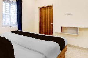 瓦朗加尔Hotel O Rainbow的木门房间的一张床位 更多31张照片