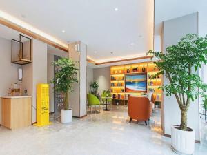 a lobby with trees and chairs in a building at Jinjiang Inn Wuhan Linjiaohu Wanda Branch in Wuhan