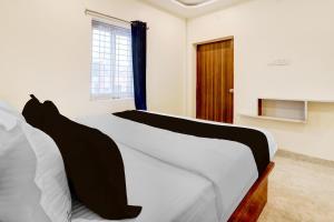 瓦朗加尔Hotel O Rainbow的卧室里有一张铺着白色床单的床和一扇窗户