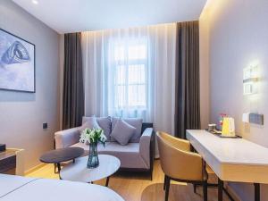a living room with a couch and a table at Jinjiang Inn Wuhan Linjiaohu Wanda Branch in Wuhan