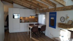 een keuken met witte kasten en een tafel en stoelen bij LAAX Homes Casa Partnun 2-9 in Laax-Murschetg