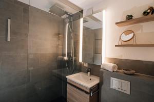 een badkamer met een wastafel en een douche bij LAAX Homes Casa Partnun 2-9 in Laax-Murschetg