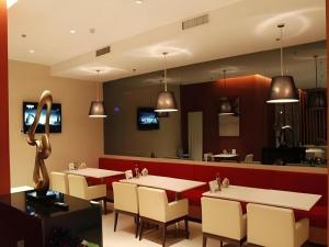 a restaurant with tables and chairs and a bar at Jinjiang Inn Yantai Fushan District Fuhai Road in Yantai