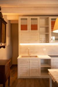 een keuken met witte kasten en een spoelbak bij Country House Il Vecchio Ippocastano Adults only in Cascia