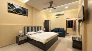 een slaapkamer met een bed en een blauwe stoel bij Mavika Stay in Navi Mumbai