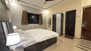 een slaapkamer met een bed, een raam en een deur bij Mavika Stay in Navi Mumbai +67 foto's