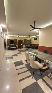 een woonkamer met een glazen tafel en stoelen bij Mavika Stay in Navi Mumbai