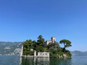 een kasteel op een eiland in het water bij Historic house by the lake La Renée Casa Vacanza in Predore