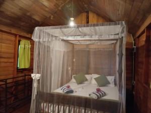 a bedroom with a canopy bed with pillows at Echo retreat in Tangalle