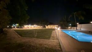 een zwembad 's nachts met verlichting in een tuin bij Mavika Stay in Navi Mumbai