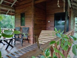 a porch of a wooden cabin with a table and chairs at Echo retreat in Tangalle