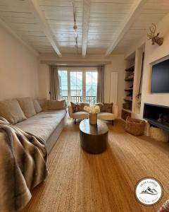 een woonkamer met een bank en een tafel bij Arties Lodge in Arties