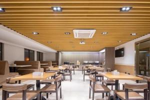 a dining room with wooden tables and chairs at 7 Days Inn Suzhou Mudu Ancient Town Kaima Auto Market in Suzhou
