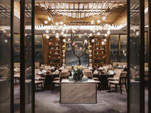 ein Esszimmer mit Tischen und Stühlen und einem Kronleuchter in der Unterkunft Pullman Fuzhou Tahoe in Fuzhou