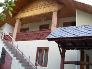 a house with a balcony and stairs on it at Casa dintre lacuri in Malaia