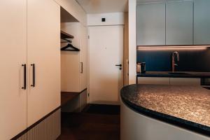 una cucina con mobili bianchi e un piano di lavoro di Casa Partnun 4-3 a Laax-Murschetg