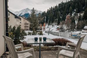 un tavolo con due sedie e due tazze sopra di Casa Partnun 4-3 a Laax-Murschetg