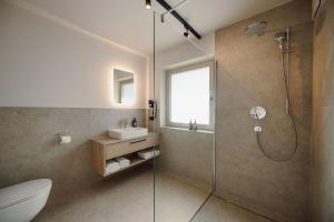 ein Badezimmer mit Dusche, Toilette und Waschbecken in der Unterkunft Hotel loj - our kind of place in Flachau