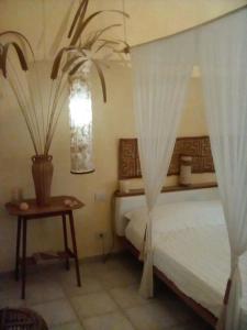 Un dormitorio con una cama y una mesa con una planta en Marina's House, en La Spezia