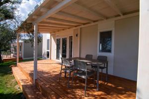 a patio with a table and chairs on a deck at Agricamping Est Garda Home Rubino in Lazise