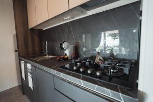 a kitchen with a black stove and a sink at Agricamping Est Garda Home Rubino in Lazise
