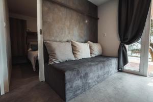 a couch sitting in a room with a window at Agricamping Est Garda Home Rubino in Lazise +19 photos
