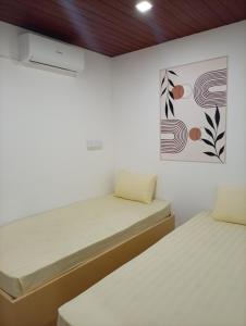 een slaapkamer met twee bedden en een schilderij aan de muur bij Airport Transit Motel in Katunayaka
