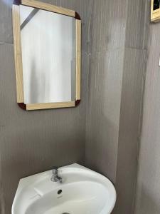 une salle de bains avec un lavabo blanc et un miroir dans l'établissement Neels&Bill's Apartment, à Bangkok