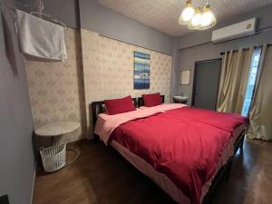 - une chambre avec un grand lit et des draps rouges dans l'établissement Neels&Bill's Apartment, à Bangkok