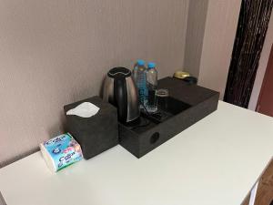 une boîte noire contenant une bouilloire et des bouteilles d'eau dans l'établissement Neels&Bill's Apartment, à Bangkok