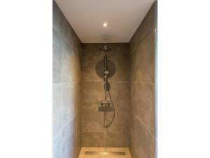 a shower with a shower head in a bathroom at Modern villa in De Cocksdorp near the beach in De Cocksdorp +20 photos