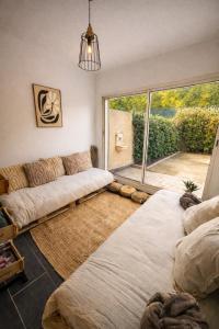 ein Wohnzimmer mit Couch und großem Fenster in der Unterkunft Villa Pampa Aix-en-Provence in Aix-en-Provence