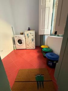 a kitchen with a washing machine and a red floor at Summer Haze Ericeira in Ericeira