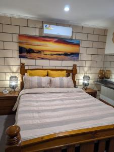 een slaapkamer met een groot bed met een schilderij aan de muur bij Lighthouse Lodge in Devonport
