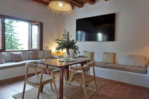 een woonkamer met een tafel, stoelen en een bank bij Villa Cala Xuclar in Portinatx