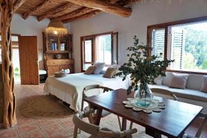 een slaapkamer met een bed, een tafel en een bank bij Villa Cala Xuclar in Portinatx +45 foto's