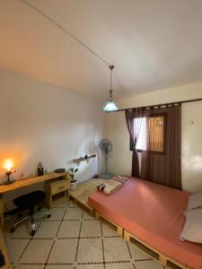 Schlafzimmer mit einem großen rosa Bett und einem Schreibtisch in der Unterkunft Villa Éden in Dakar