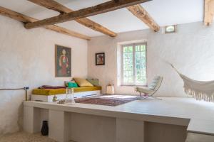 ein Zimmer mit einem Tisch und einem Bett und einem Fenster in der Unterkunft La Manufacture Royale 1739 in Montolieu + 102 Fotos