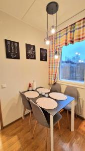 a dining room with a table and chairs and a window at Kotoisa Kaksio Levähdä Täällä ja Parkki in Lahti +19 photos